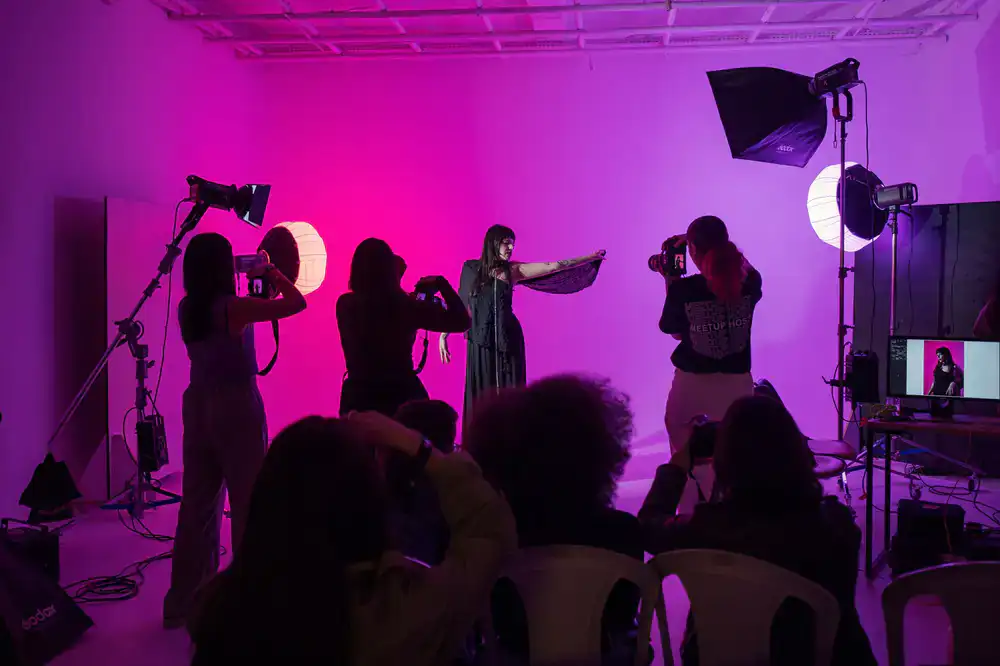 Instructor demonstrating aerial hoop techniques to a group of attentive students